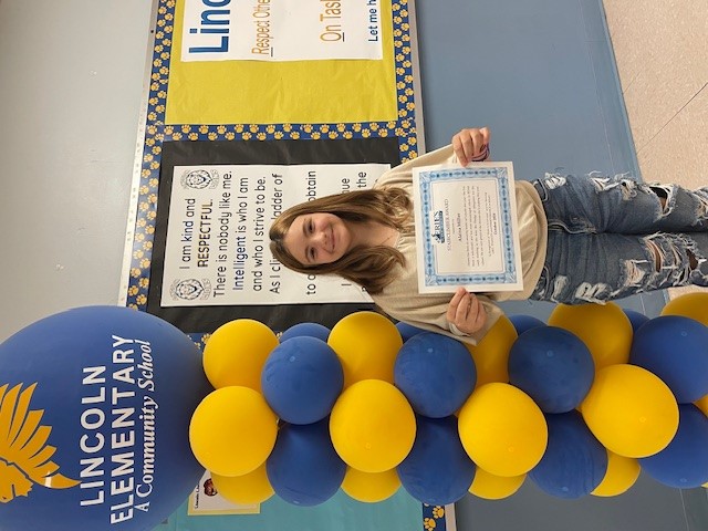 Lincoln's October Stairclimber, Alaina Miller, poses with her certificate.